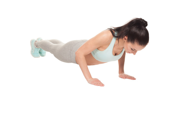 αθλητική γυναίκα κάνει push-ups σε λευκό φόντο. Γυμναστήριο mod - Φωτογραφία, εικόνα