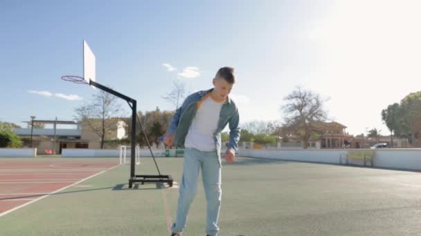 Genç adam güneşli bir günde parkta basketbol antrenmanı yapıyor. - Video, Çekim