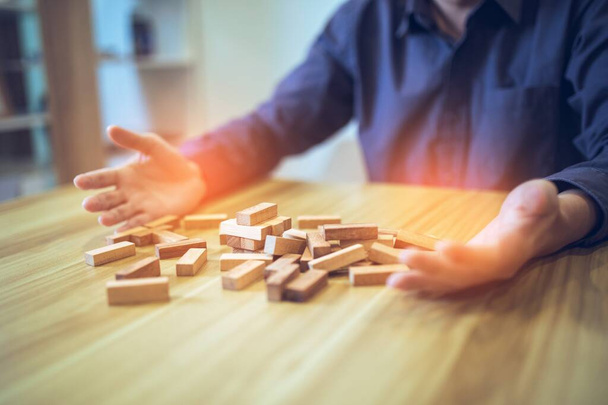 Business strategy concept with hands playing a wooden block tower game, symbolizing risk and stability. Planning risk management. - Photo, Image