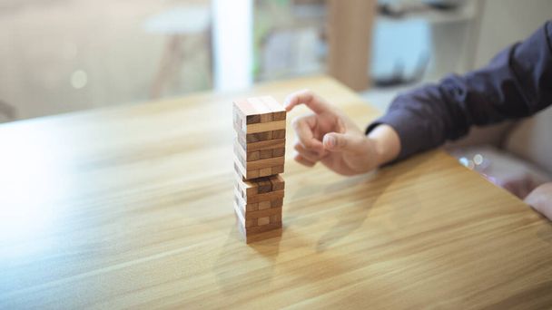 Podnikání strategický koncept s rukama hraje hru dřevěné blokové věže, symbolizující riziko a stabilitu. Řízení rizik plánování. - Fotografie, Obrázek