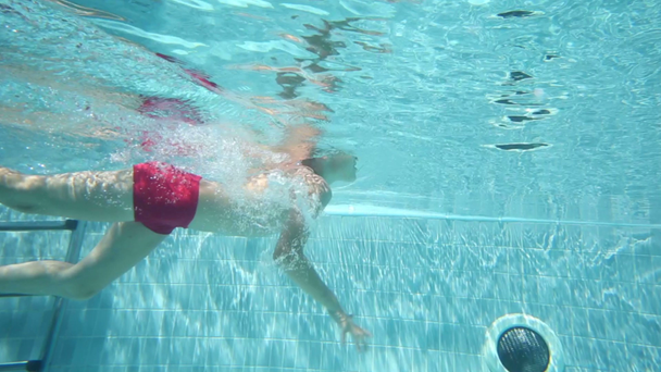 Menino nadando na piscina com nadadeiras
 - Filmagem, Vídeo