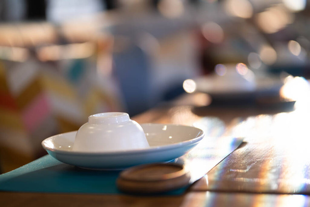 Tazze e piatti sul tavolo da pranzo bokeh sfondo chiaro. - Foto, immagini