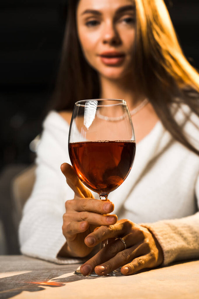 Mladá žena drží sklenku vína.Žena pije víno v restauraci.Červené víno koncept - Fotografie, Obrázek