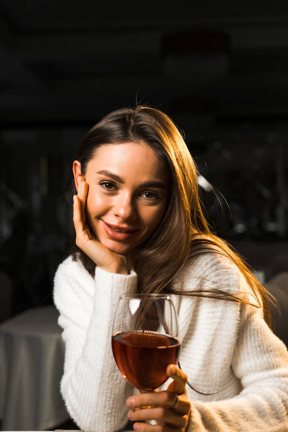 Fiatal nő kezében egy pohár bor.Nő bort iszik egy étteremben.Vörösbor koncepció - Fotó, kép
