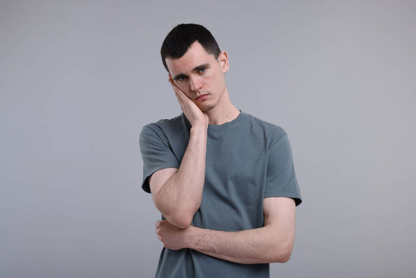 Portrait of sad man on grey background - Фото, изображение