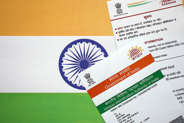 Tarjeta india Aadhaar de la Autoridad Única de Identificación de la India en bandera india de cerca - Foto, imagen