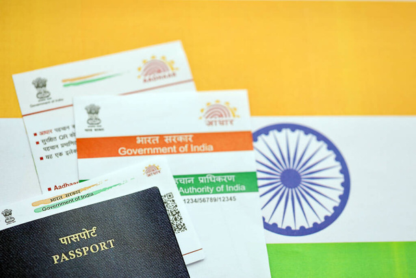Tarjeta Aadhaar india de la Autoridad Única de Identificación de la India y Pasaporte en bandera india de cerca - Foto, imagen
