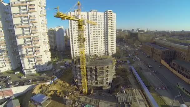 Tall lifting crane works on building site - Filmati, video