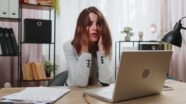Tired sleepy young businesswoman sitting at home office desk with laptop overworked lazy bored lady worker feel fatigue exhausted of work deprived. Exhausted workaholic freelancer workaholic girl - Footage, Video