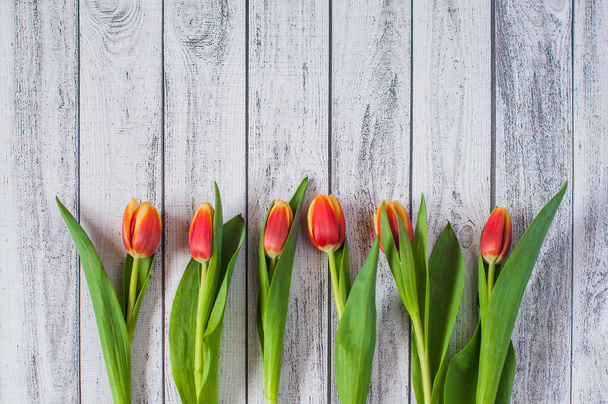 A bouquet of yellow and pink tulips on a wooden background - Photo, Image