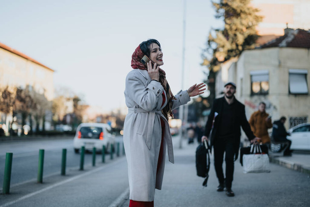 A young businessman laden with shopping bags confronting his girlfriend who is engaged in a phone call. The couple appears to be in the middle of a conversation on a city street. - Photo, Image