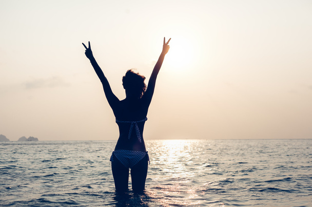 Woman enjoying freedom feeling happy at beach at sunset - 写真・画像