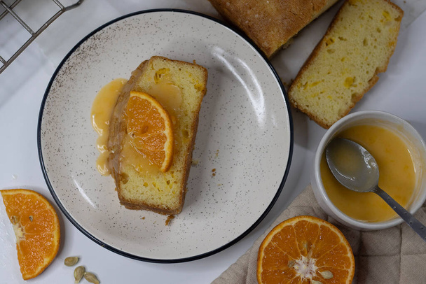Tranches de gâteau à la livre d'orange, également connu sous le nom de gâteau au pain d'agrumes ou gâteau au beurre d'orange. Dessert moelleux et savoureux, avec glaçage piquant parfait pour les amateurs de cuisine, les amateurs de cuisson et pour les envies sucrées - Photo, image
