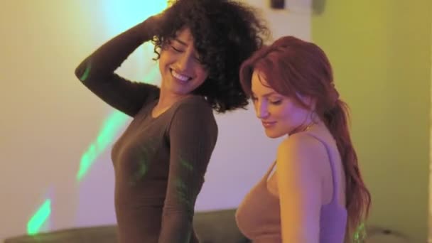 Zeitlupenvideo von zwei multiethnischen, sinnlichen Frauen, die zusammen auf einer Heimparty tanzen - Filmmaterial, Video