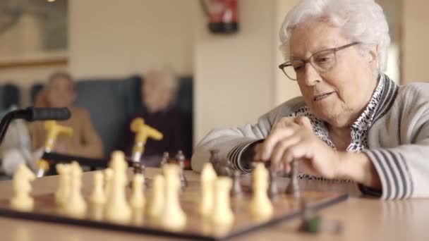 Video al rallentatore di due amici anziani che giocano a scacchi in una scacchiera geriatrica - Filmati, video