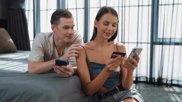 Νεαρό ζευγάρι αισθάνονται ενθουσιασμένοι και ευχαριστημένοι μετά τη χρήση online εφαρμογή πληρωμής και ψηφιακό πορτοφόλι στο smartphone για να πληρώσει με πιστωτική κάρτα. Αγορές ηλεκτρονικού εμπορίου και σύγχρονες αγορές μέσω mobile internet. Διεύθυνση - Πλάνα, βίντεο