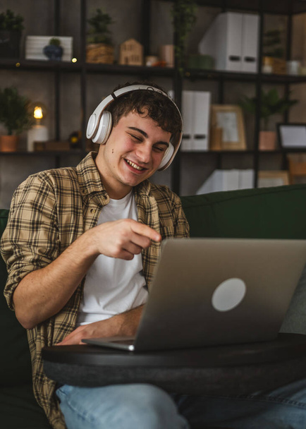 Um homem adolescente caucasiano usar computador portátil tem chamada de vídeo em casa - Foto, Imagem