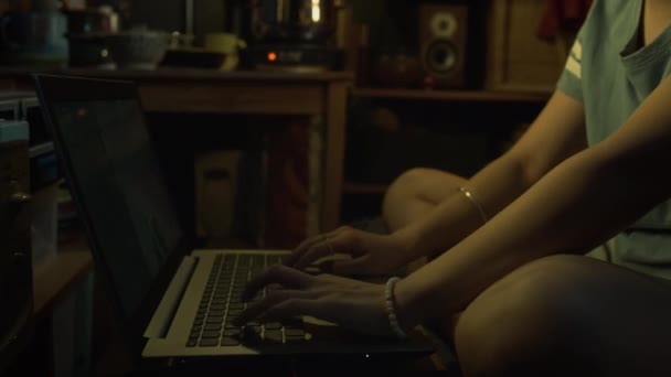 Średni strzał z bliska azjatyckiej kobiety gracz siedzi na łóżku piętrowym w małym mieszkaniu, grając FPS shooter na laptopie online, przegrywając mecz, zrywając słuchawki i reagując z gniewem i rozczarowaniem - Materiał filmowy, wideo