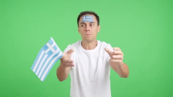 Wideo w studiu z chromą mężczyzny machającego grecką flagą narodową wściekły na decyzję sędziów - Materiał filmowy, wideo