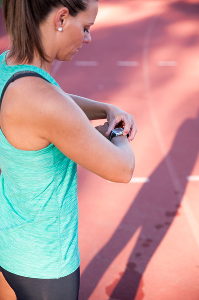 immagine ravvicinata di un'atleta femminile che regola il suo cardiofrequenzimetro
 - Foto, immagini