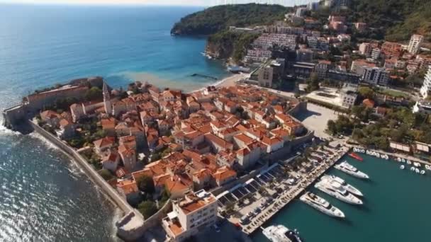 Een prachtige stad aan het water met boten aangemeerd in de haven, omgeven door gebouwen en stranden, met een prachtig stedelijk ontwerp en landschap - Video