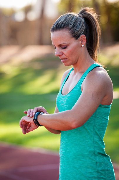 image of a female athlete adjusting her heart rate monitor - Fotó, kép