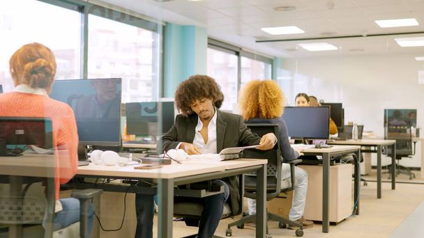 Equipe de jeunes collaborateurs multiethniques travaillant avec des ordinateurs sur des bureaux - Photo, image