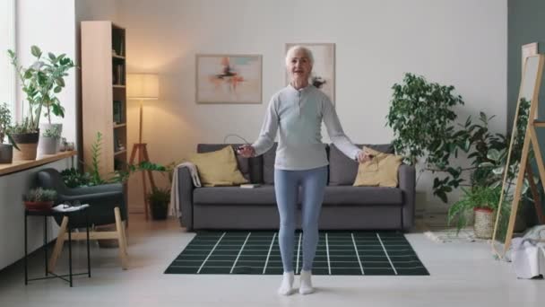 Voller Stich auf kaukasische Seniorin in Aktivkleidung beim Seilspringen beim Heimtraining - Filmmaterial, Video