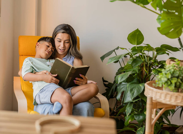 Bir anne ve oğul kitap okurken huzurlu bir anı paylaşırlar.. - Fotoğraf, Görsel