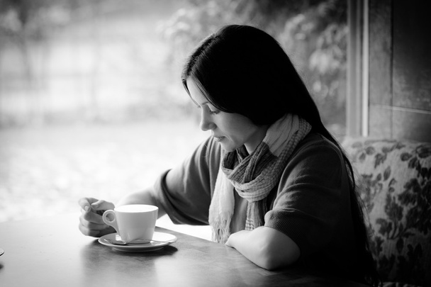 Belle jeune femme avec une tasse de thé dans un café - Photo, image