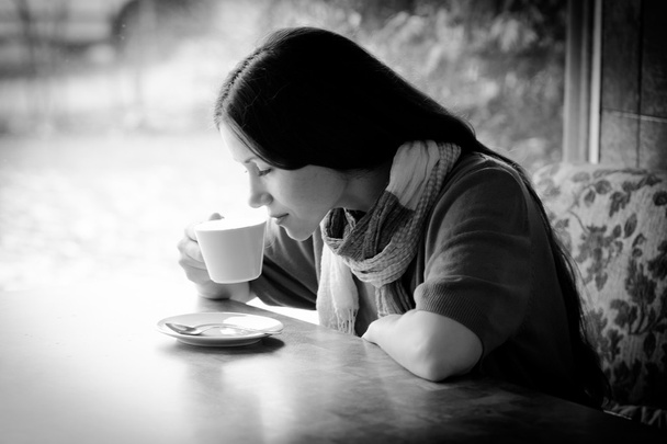 Красива молода жінка з чашкою чаю в кафе
 - Фото, зображення