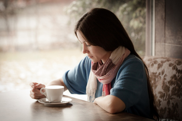 Gyönyörű fiatal nő egy csésze teával egy kávézóban. - Fotó, kép
