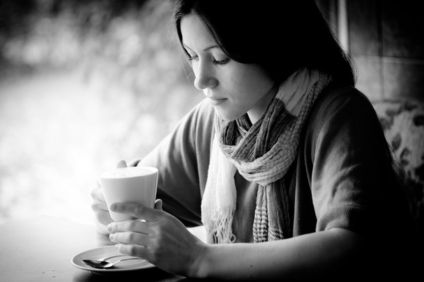 Bella giovane donna con una tazza di tè in un caffè - Foto, immagini