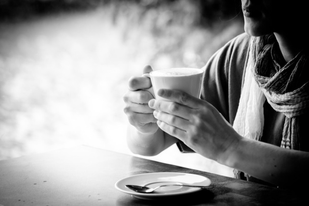 žena ruce s latté na dřevěném stole - Fotografie, Obrázek