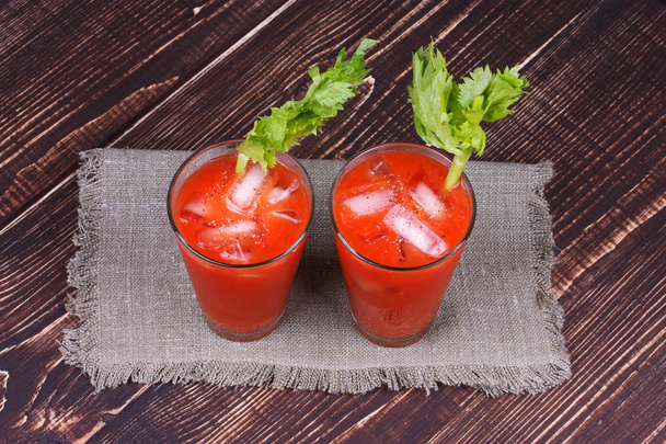 Bloody mary cocktails served with celery on wooden background - Fotografie, Obrázek