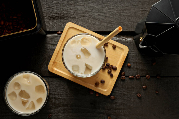 Vasos con café helado, cafetera y granos de café sobre fondo de madera oscura, vista superior - Foto, imagen