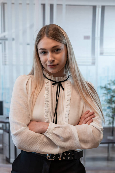 Beautiful blonde business woman in a white blouse in office building. Fashion portrait, lifestyle - Photo, Image