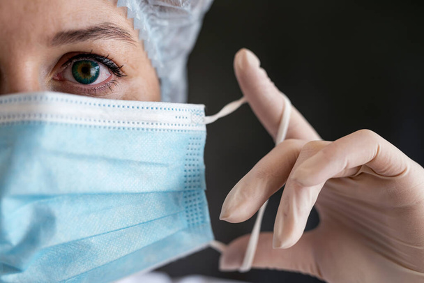  Caucasian female medical nurse putting sterile mask, safety equipment - 写真・画像