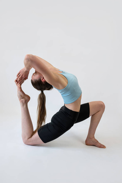 Jonge vrouw aan het stretchen, geïsoleerd op witte achtergrond. Workout en fitness concept - Foto, afbeelding