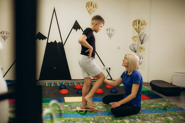 Kind auf Sensorische Matte Massage während sensorische Integration Sitzung. Mädchen in Reha-Zentrum mit Physiotherapeut bei orthopädischer Korrektur. - Foto, Bild