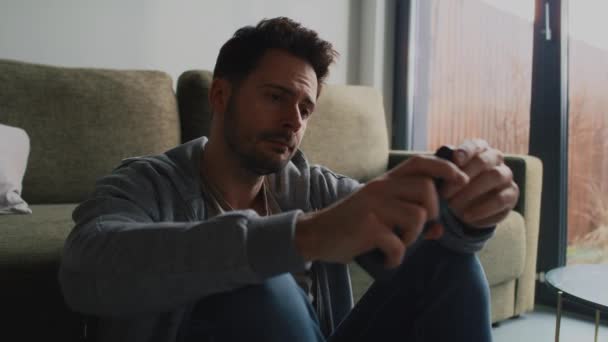 Pozorný a úzkostlivý muž kontrolující mobilní telefon - Záběry, video