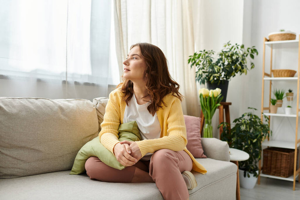Женщина средних лет расслабляется на диване в гостиной. - Фото, изображение