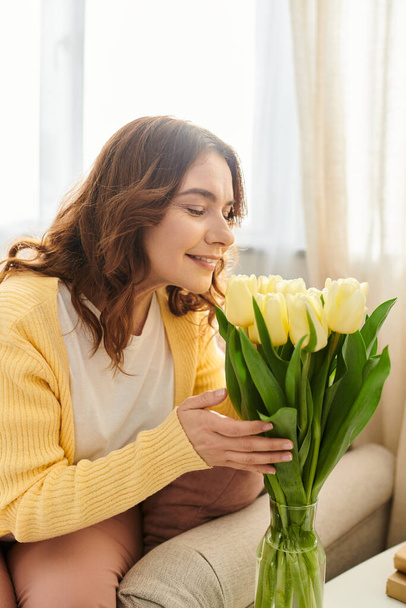 Mulher de meia idade desfrutando de flores no sofá. - Foto, Imagem