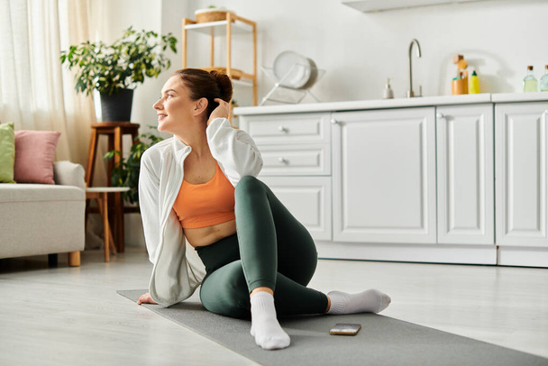 Donna di mezza età pratica pacificamente yoga su un tappeto in un ambiente accogliente soggiorno. - Foto, immagini