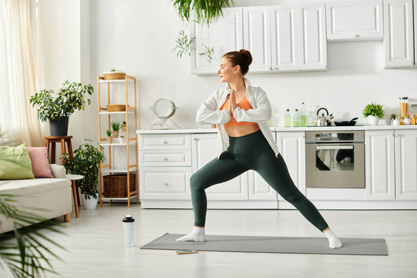 Жінка середнього віку в позі йоги, в білій сорочці і легінсах. - Фото, зображення