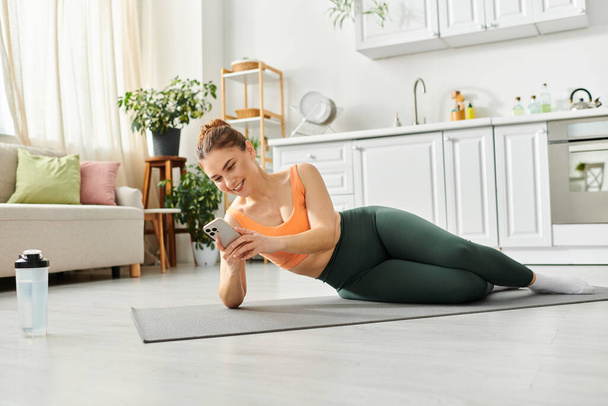 Donna di mezza età equilibri in posa yoga sul tappeto a casa. - Foto, immagini
