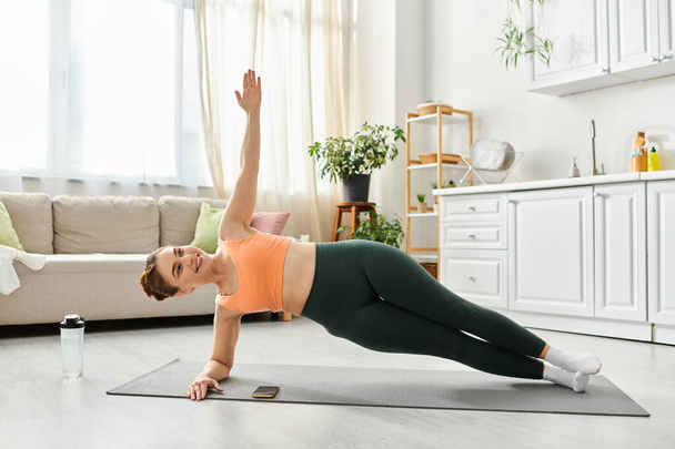Frau mittleren Alters vollführt anmutig Yoga-Pose in gemütlichem Wohnraum. - Foto, Bild