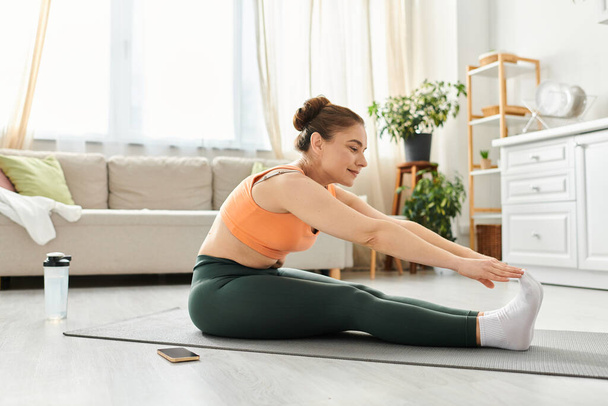 Mujer de mediana edad realizando con gracia una pose de yoga en una acogedora sala de estar. - Foto, imagen
