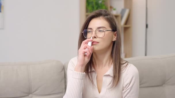 Retrato mulher doente usando spray nasal para tratamento de doenças respiratórias - Filmagem, Vídeo