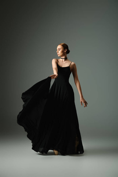 Uma jovem mulher em um vestido preto marcando uma pose. - Foto, Imagem